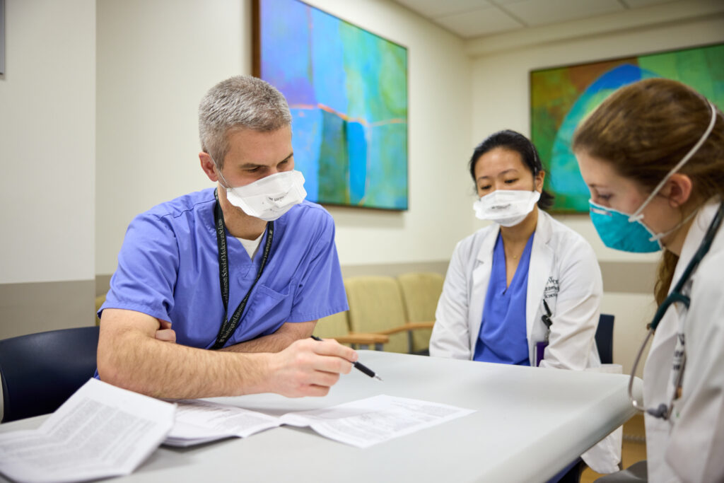 Hospitalist Nathan Martin, MD, goes on rounds with third-year MD students Emma Payne and Amy Zhang on January 21, 2022. Coronavirus MATT MILLER/WASHU SCHOOL OF MEDICINE