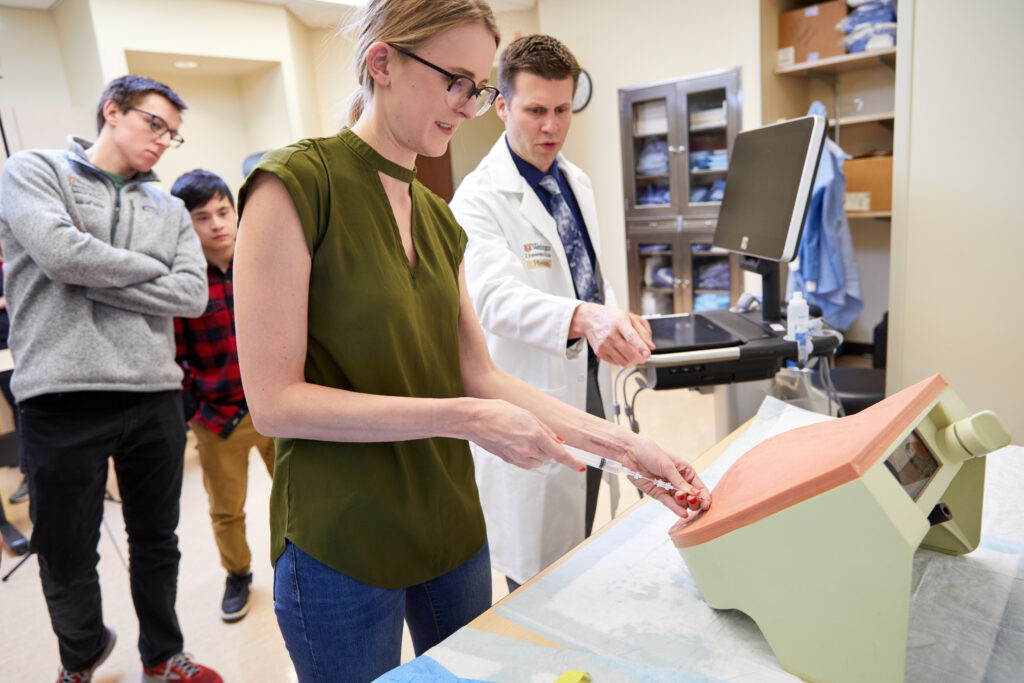 Matt Freer, MD, explains a paracentesis procedure to fourth-year medical students in the capstone course at the Howard and Joyce Wood Simulation Center in the Farrell Learning and Teaching Center on February 19, 2020. MATT MILLER/WASHU SCHOOL OF MEDICINE